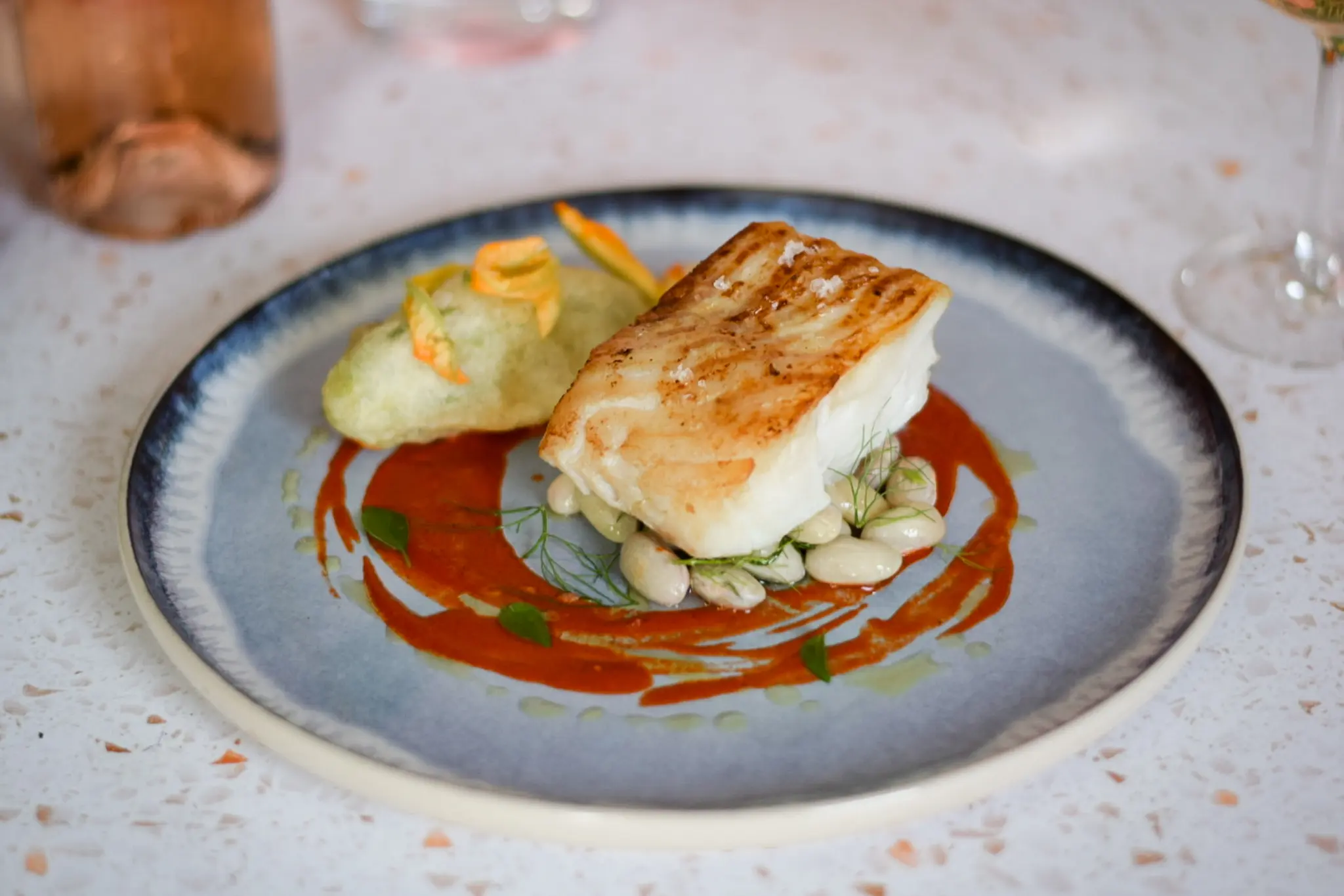 Panfried seabass with courgette flowers and red pepper by villa chef in France